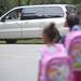 Sonja Greenfield watches her kids, Heather, 5, and Allison, 7, wait to get picked up by a bus on the first day of school at Abbot Elementary on Tuesday. Daniel Brenner I AnnArbor.com